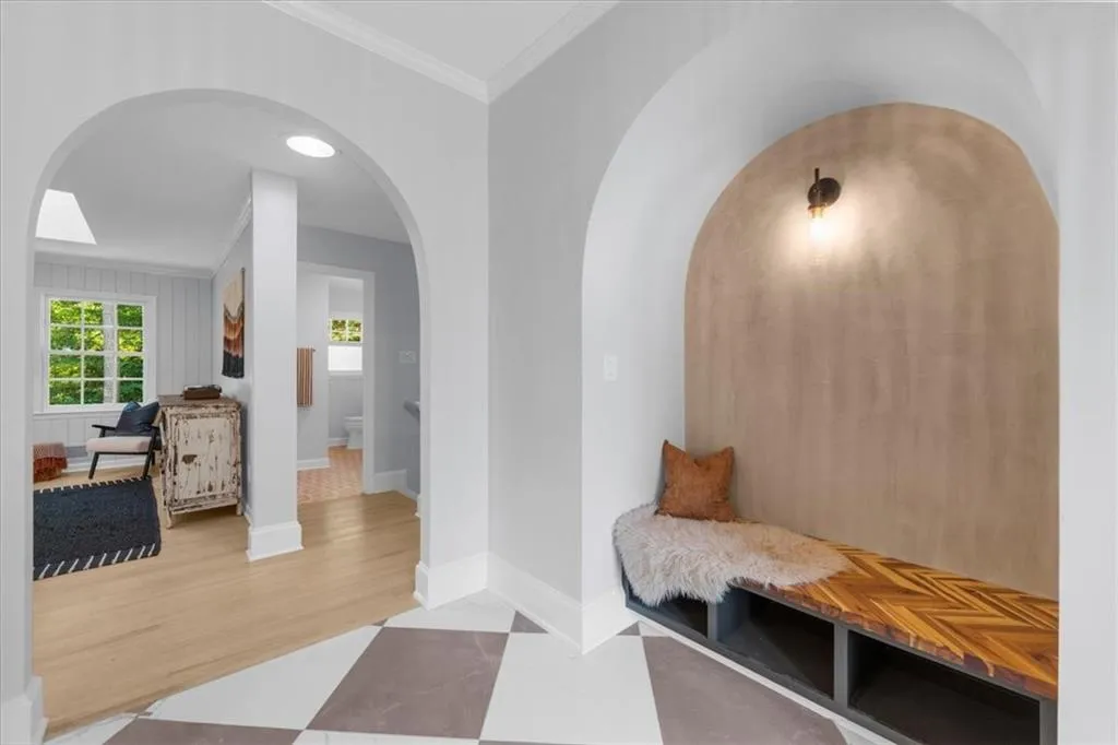 Mudroom featuring arched walkways, crown molding, healthy amount of natural light, and wood finished floors