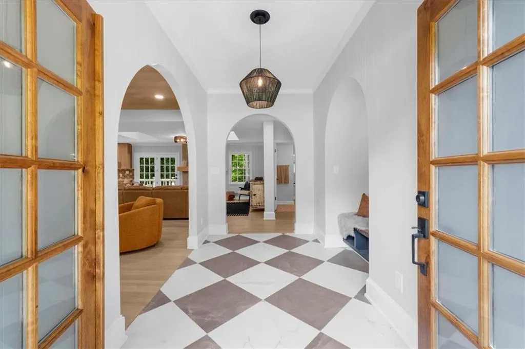 Corridor featuring arched walkways, ornamental molding, and recessed lighting