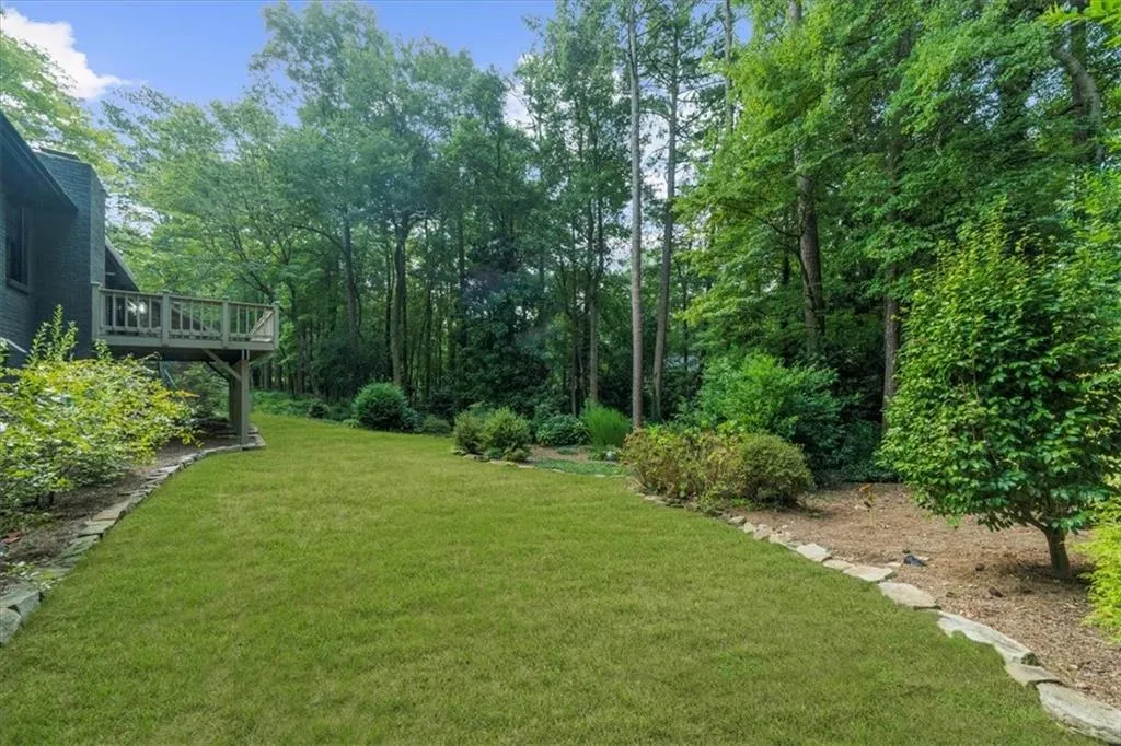 View of green lawn with a wooden deck