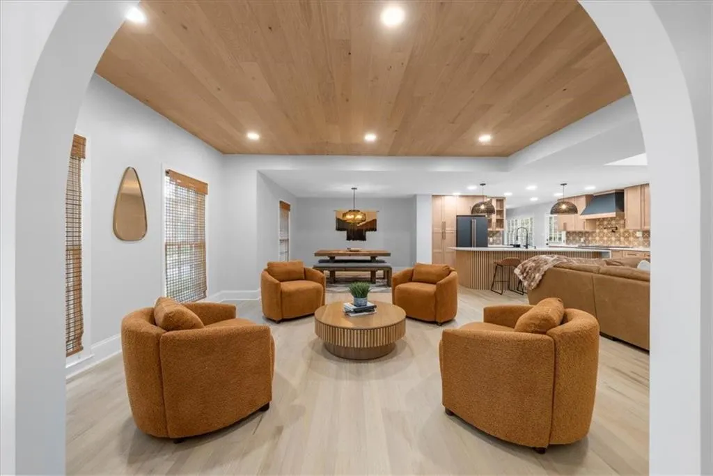 Living room featuring arched walkways, recessed lighting, wood ceiling, and light wood finished floors