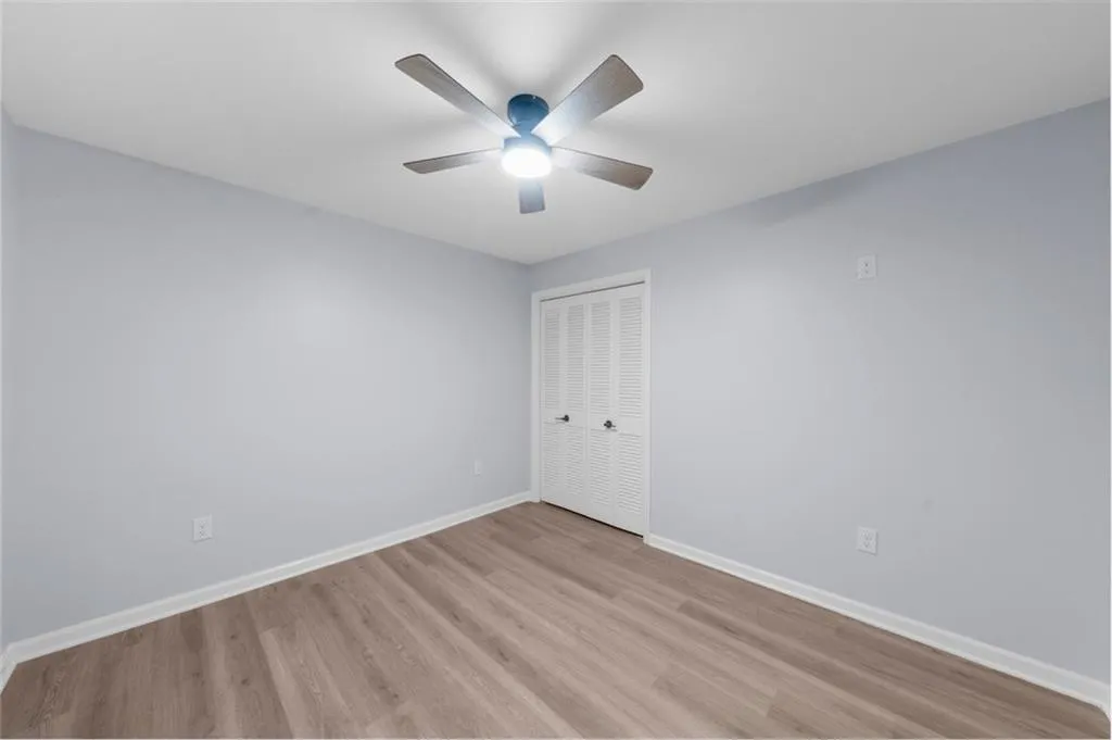 Empty room featuring light wood finished floors and ceiling fan
