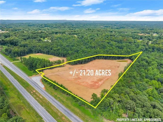 Approximately 21.20 acres of cleared land positioned along a major highway corridor, surrounded by mature forest and established residential development