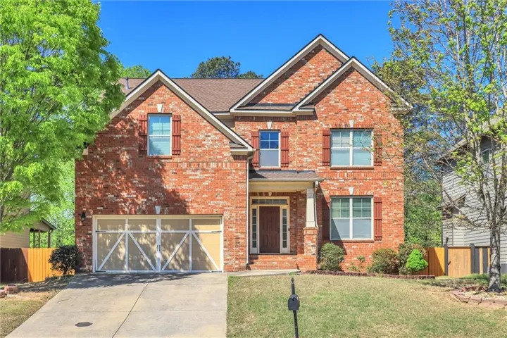 Craftsman inspired home with a garage, brick siding, and driveway