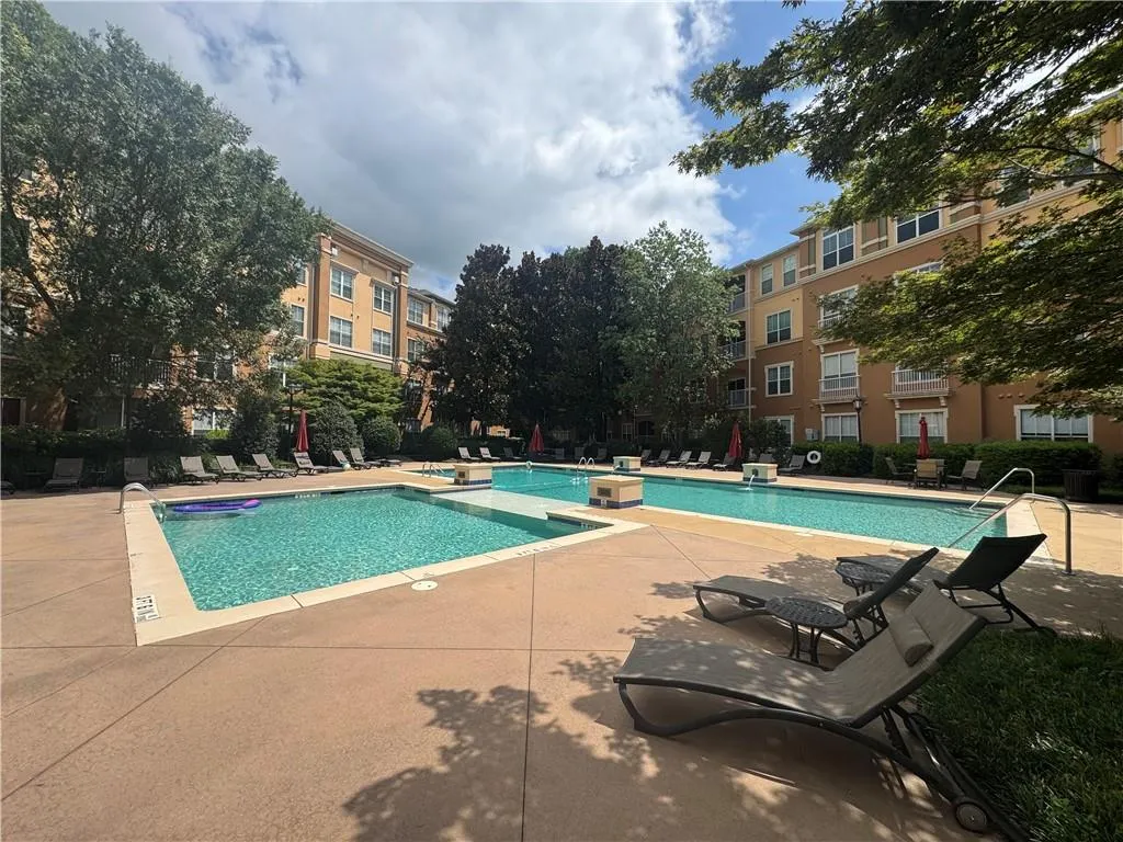 Community pool featuring a patio and a hot tub