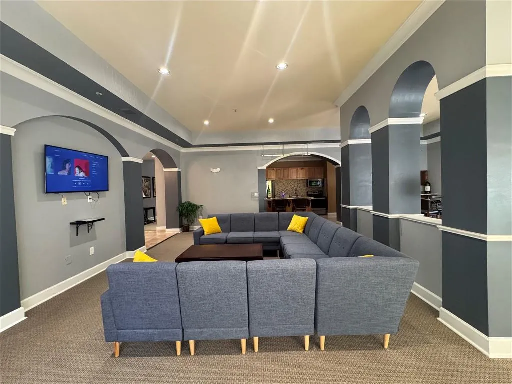 Living room with carpet, recessed lighting, arched walkways, and crown molding