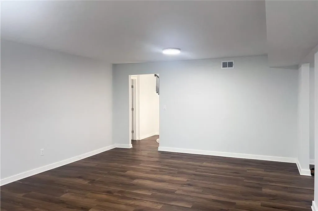 Spare room with dark wood finished floors and baseboards