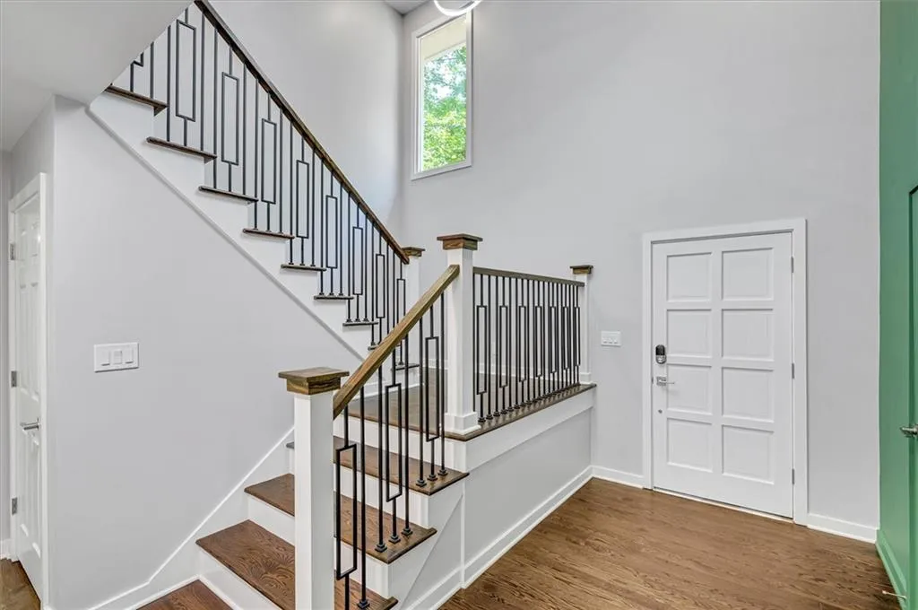 Stairway featuring wood finished floors and a towering ceiling Stairway featuring wood finished floors and a towering ceiling