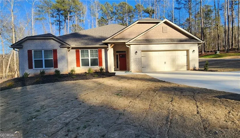 Brick exterior with red shutters, a two-car garage, and a concrete driveway