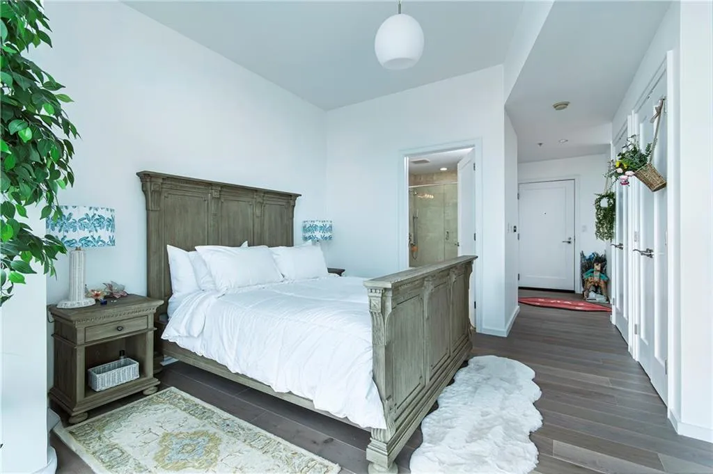 Bedroom featuring wood finished floors and ensuite bath