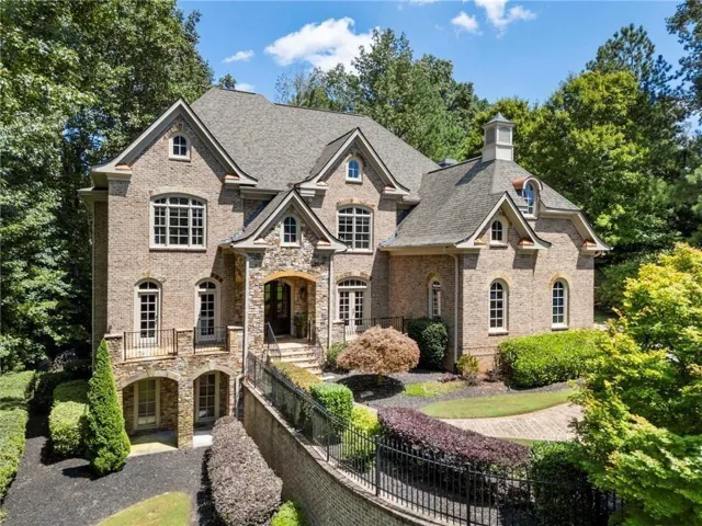 Stone and brick facade residence featuring multiple gables and a cupola