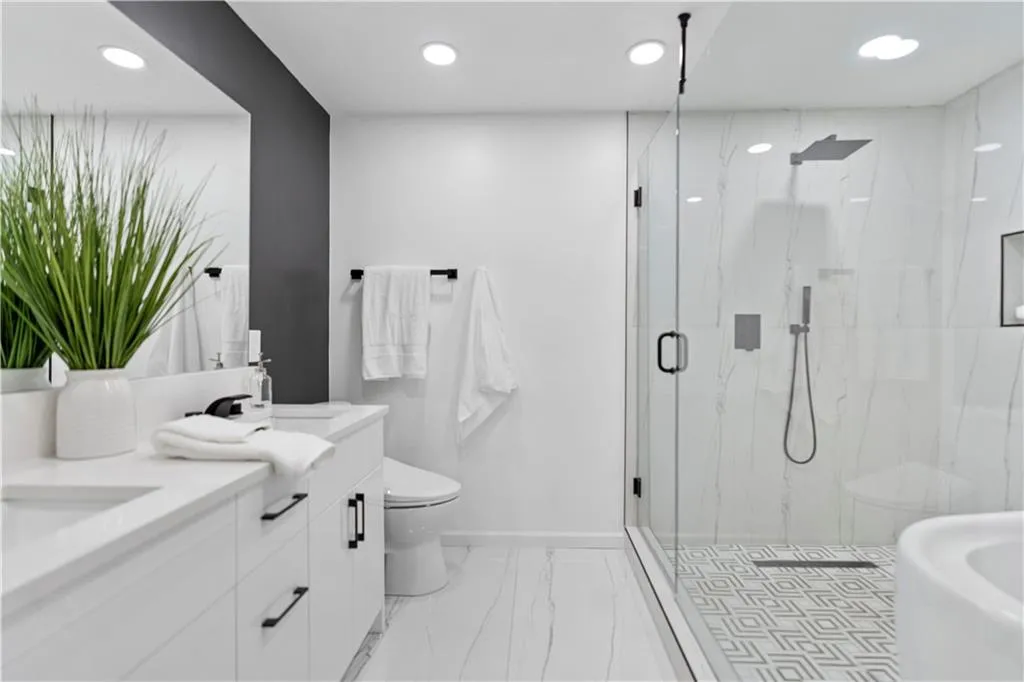 Bathroom with double vanity, a marble finish shower, marble finish flooring, and recessed lighting