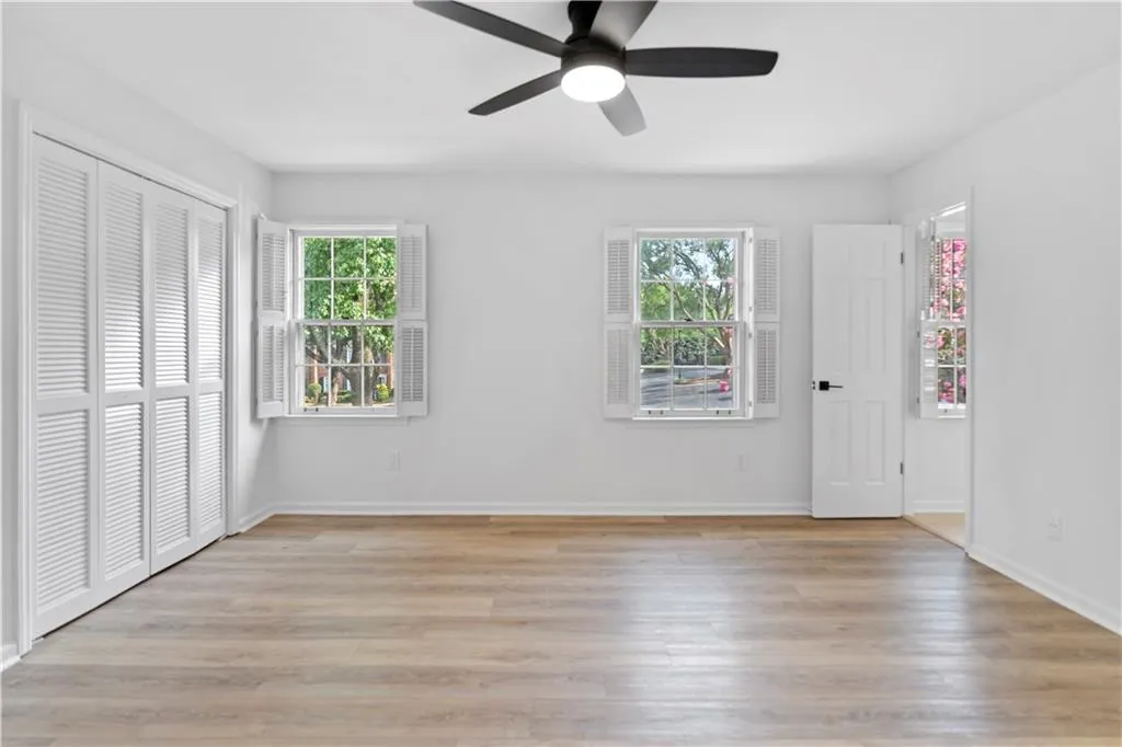 Guest bedroom featuring light wood finished floors, a closet, and ceiling fan