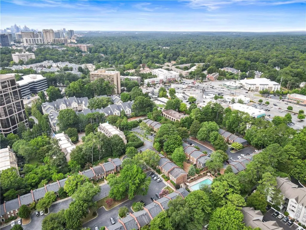 Aerial view of property and surrounding area with a heavily wooded area