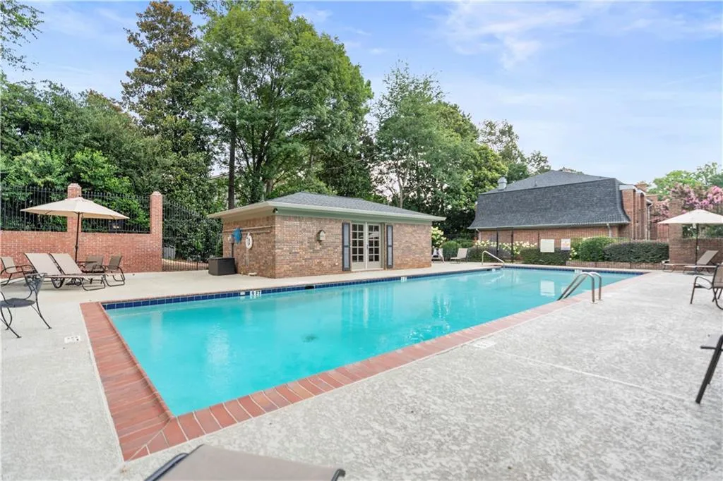 Community pool with a patio area, a storage structure, french doors, and an outbuilding