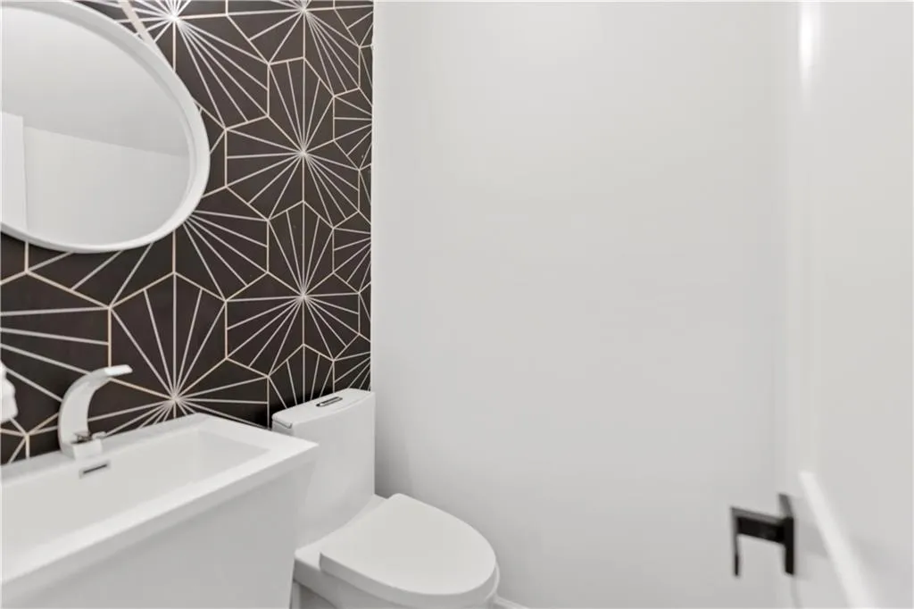 Half Bathroom featuring a sink and tile walls
