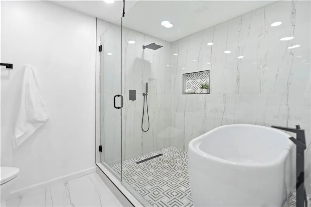 Full bathroom featuring a soaking tub, a marble finish shower, and marble finish flooring