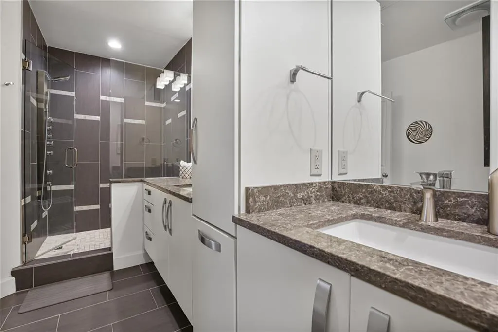 Bathroom featuring vanity, an enclosed shower, and tile floors