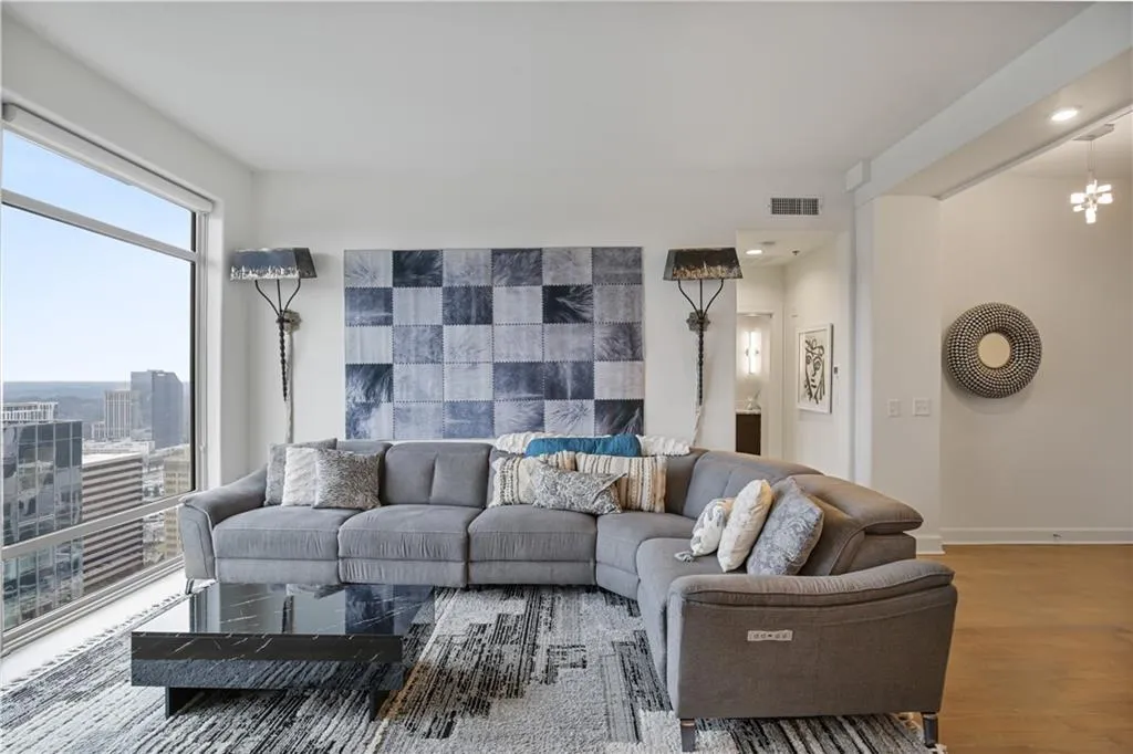 Living room featuring dark wood-type flooring and a notable chandelier