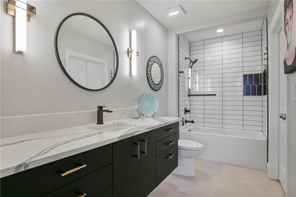 Full bathroom featuring tile floors, tiled shower / bath, vanity, and toilet