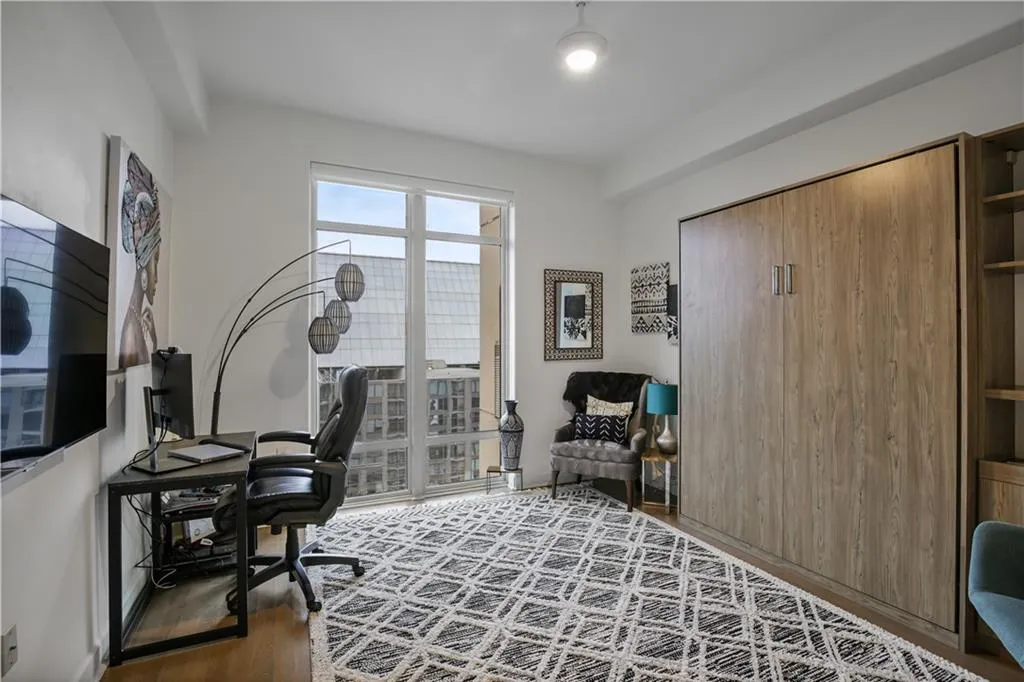 Home office with dark hardwood / wood-style flooring