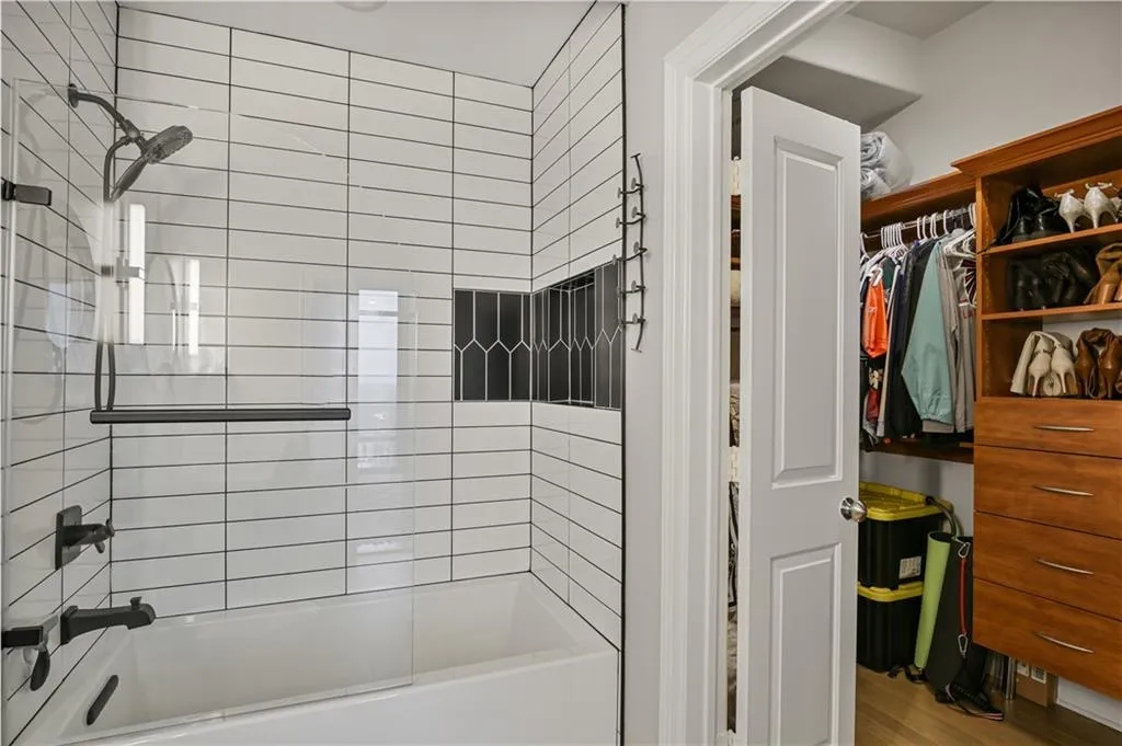 Bathroom with wood-type flooring and tiled shower / bath
