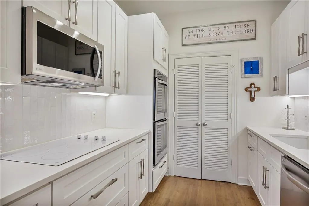 Kitchen featuring white cabinetry, appliances with stainless steel finishes, tasteful backsplash, and light wood-type flooring