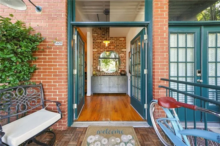 Red brick exterior with dark green French doors