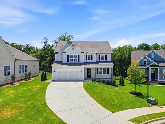 White two-story residence with dark shutters and a covered porch entry