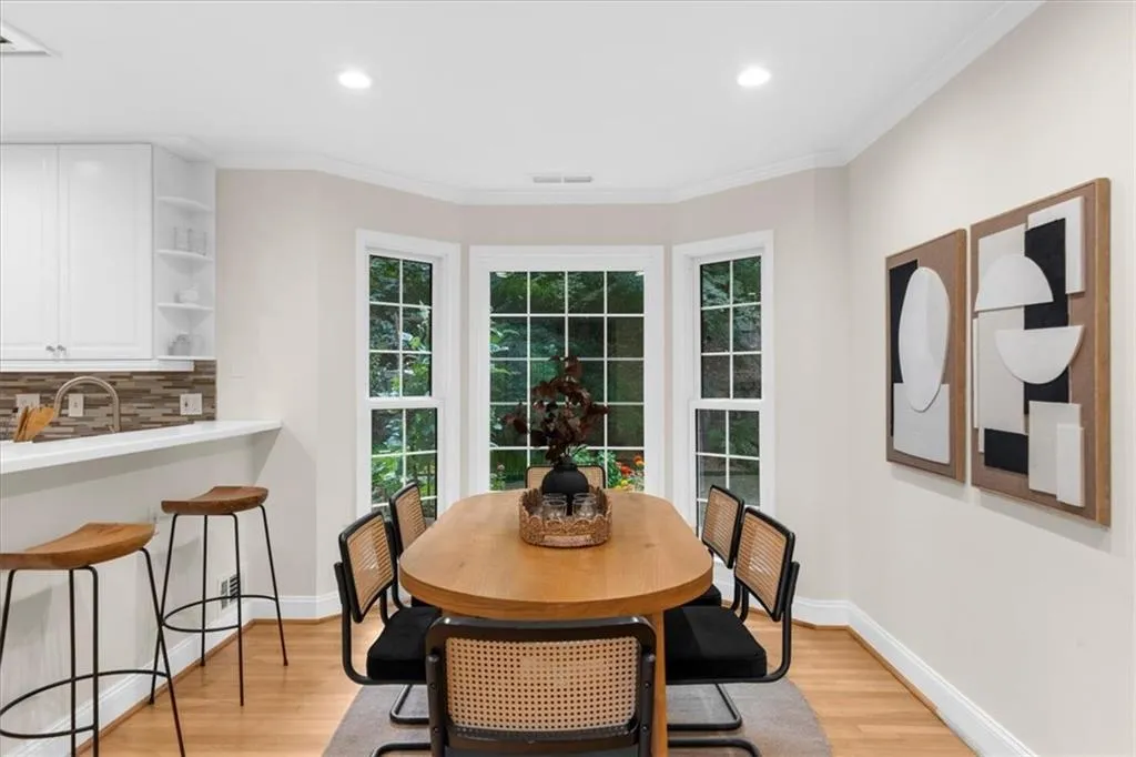 Dining room with crown molding, light wood finished floors, and recessed lighting