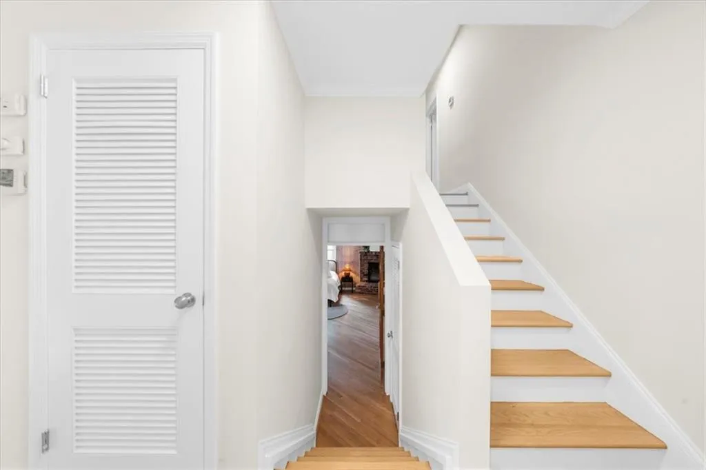Stairway with wood finished floors and baseboards