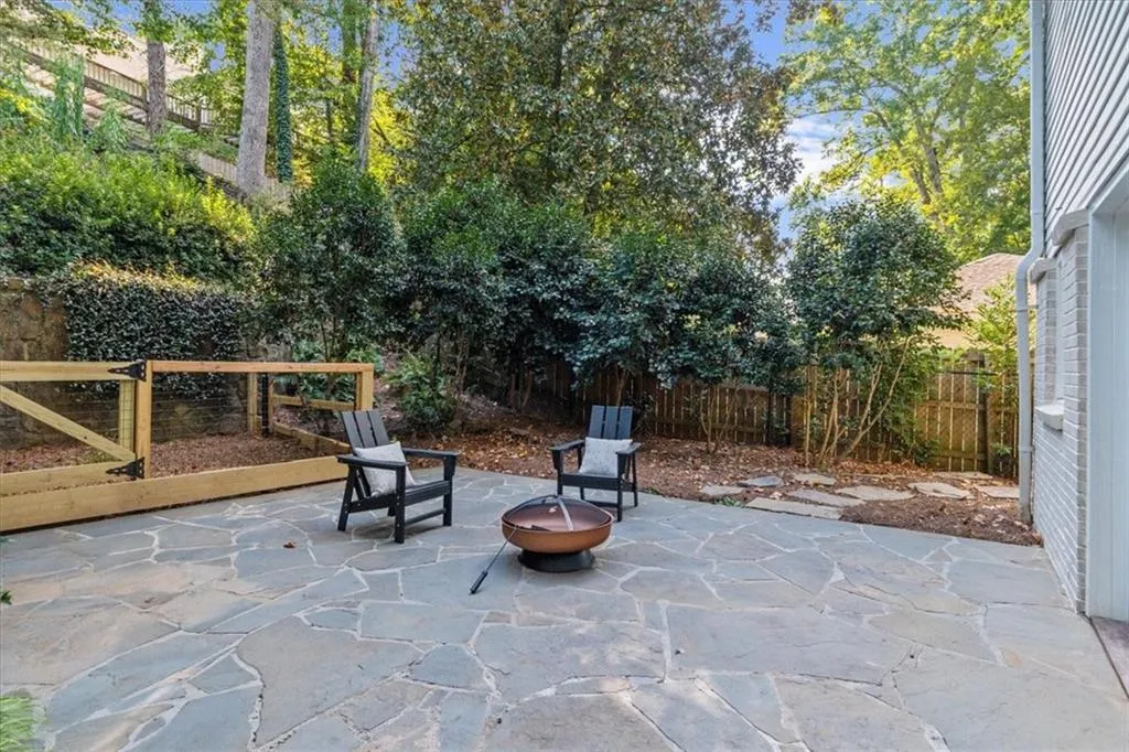 Fenced backyard with a fire pit and a patio
