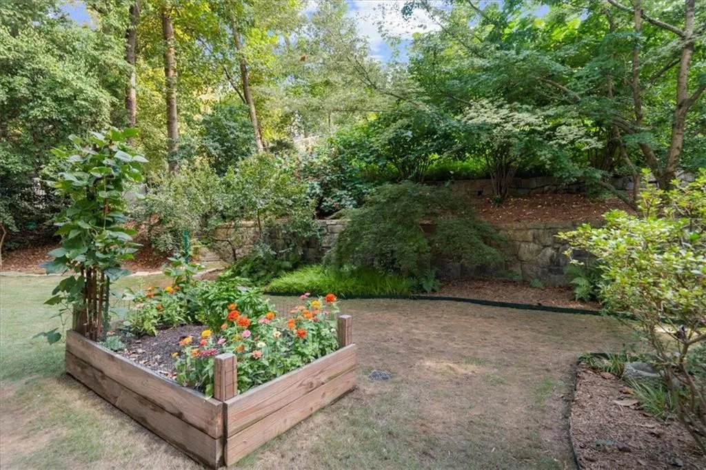 View of green lawn featuring a vegetable garden