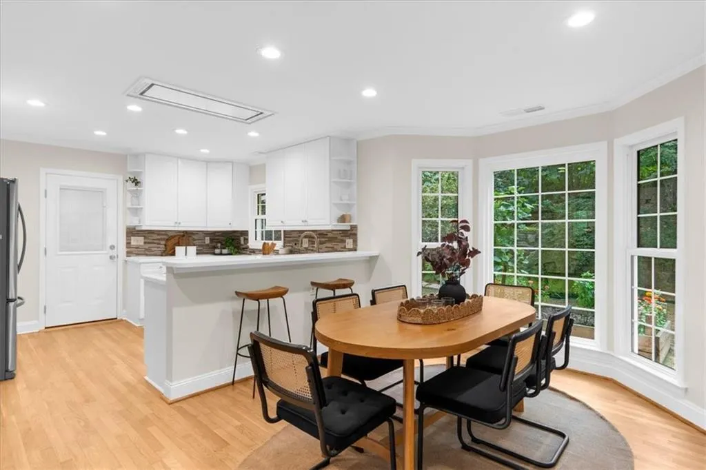 Dining area featuring light wood-style flooring, recessed lighting, attic access, and ornamental molding