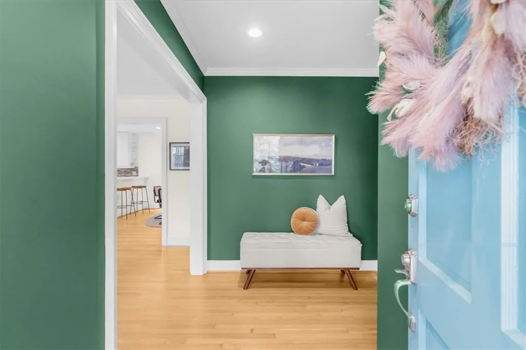 Corridor with wood finished floors and ornamental molding
