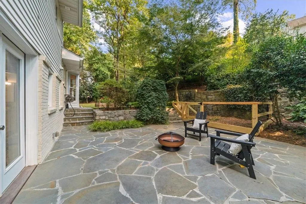 View of patio / terrace featuring an outdoor fire pit and view of scattered trees