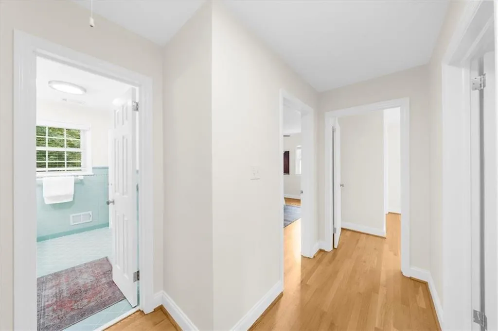 Hallway featuring light wood-type flooring and baseboards