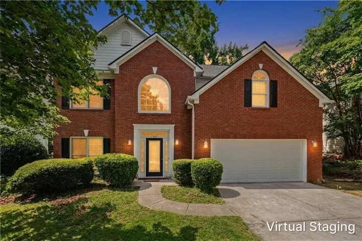 Red brick facade featuring a central arched window, white trim accents, and a covered entry