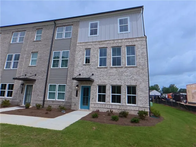 Contemporary townhome exterior featuring light gray brick and complementary horizontal siding