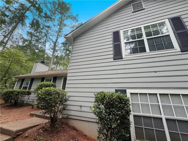 Exterior siding in a neutral tone with contrasting black shutters