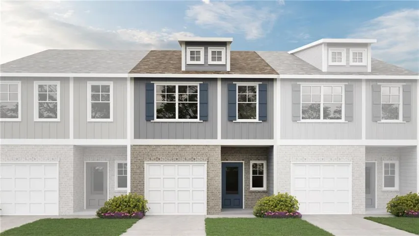 Three-story townhome with a dark blue front door, two-car garage, dormer window, and mature landscaping