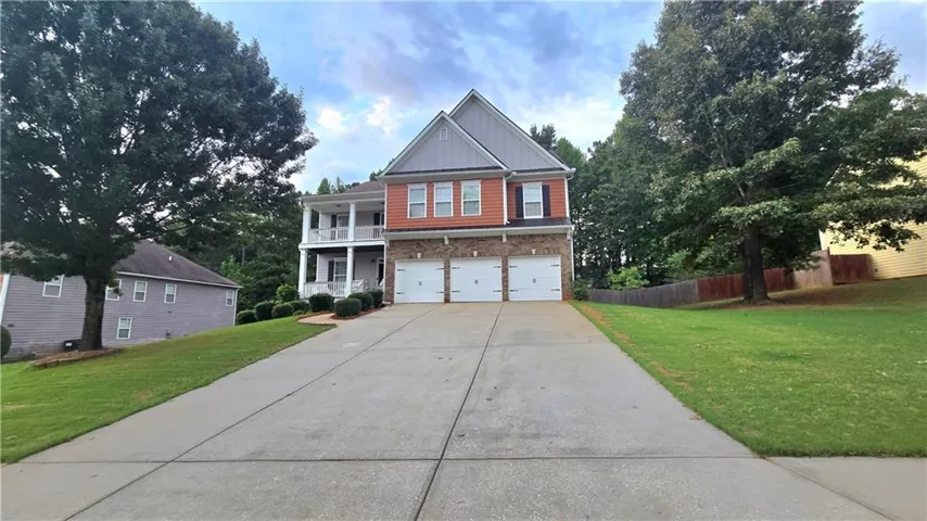 Two-story brick Colonial with a two-car attached garage and wide concrete driveway