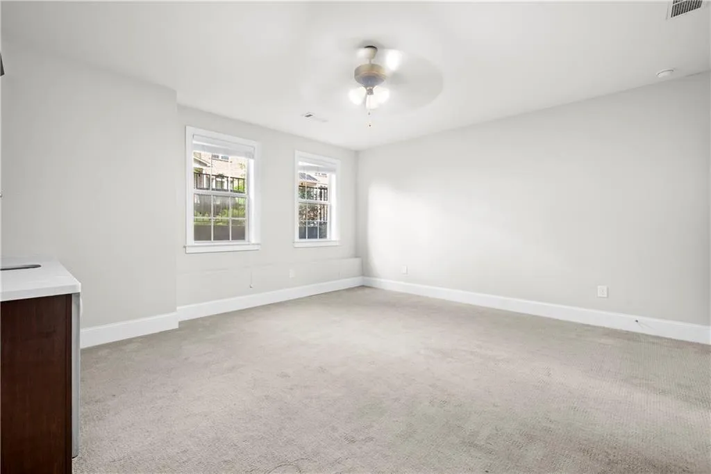 Unfurnished room featuring light carpet and a ceiling fan