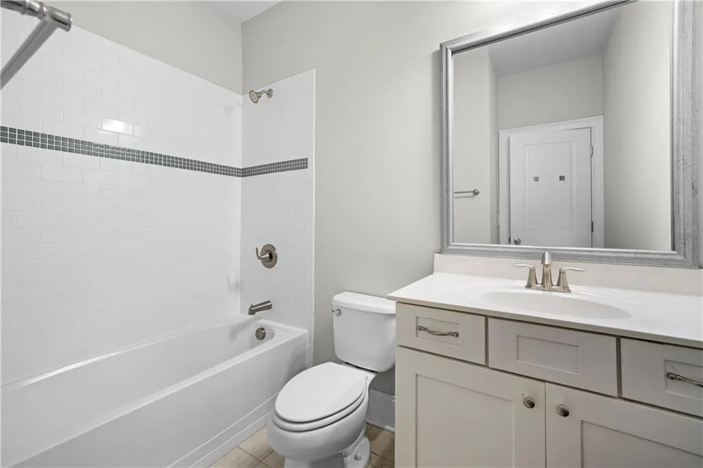 Full bath with shower / bath combination, vanity, and light tile patterned floors