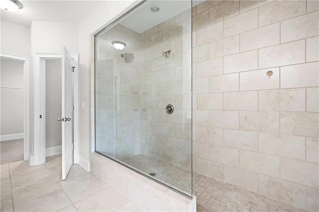 Full bath featuring walk in shower, a walk in closet, and tile patterned floors
