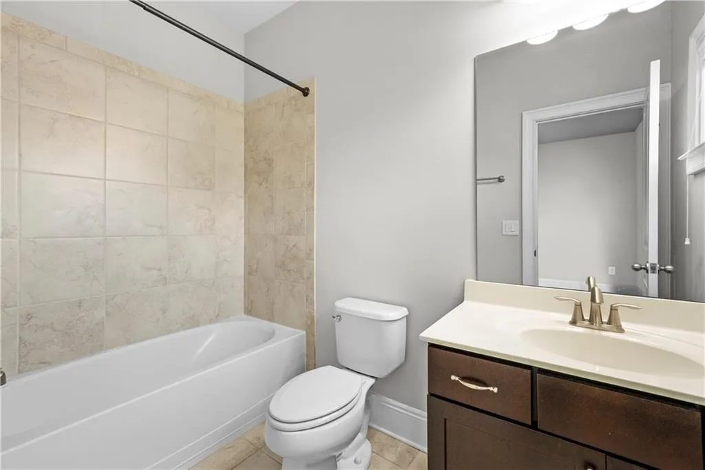 Bathroom with vanity, shower / bath combination, and light tile patterned floors