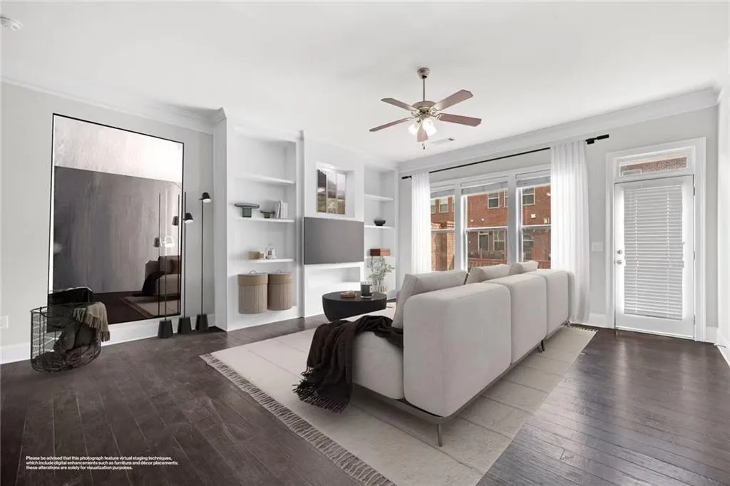 Living area with crown molding, dark wood-style flooring, built in features, and a ceiling fan