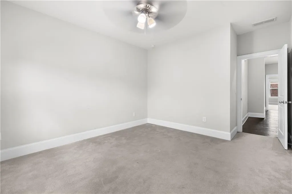 Unfurnished room with carpet floors and a ceiling fan