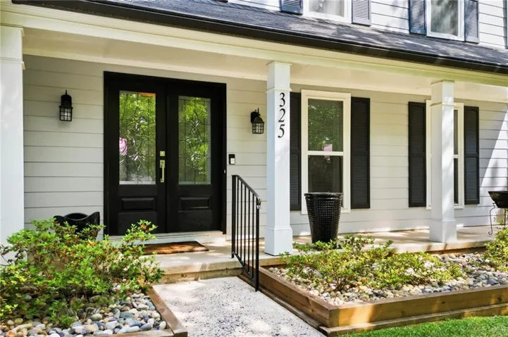 Inviting front entrance featuring double black doors with decorative glass inserts