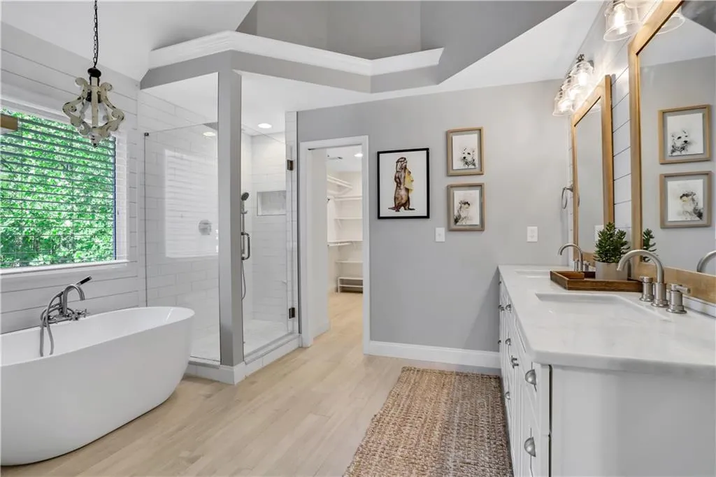 Bathroom with a wealth of natural light, hardwood / wood-style flooring, dual vanity, and separate shower and tub Bathroom with a wealth of natural light, hardwood / wood-style flooring, dual vanity, and separate shower and tub