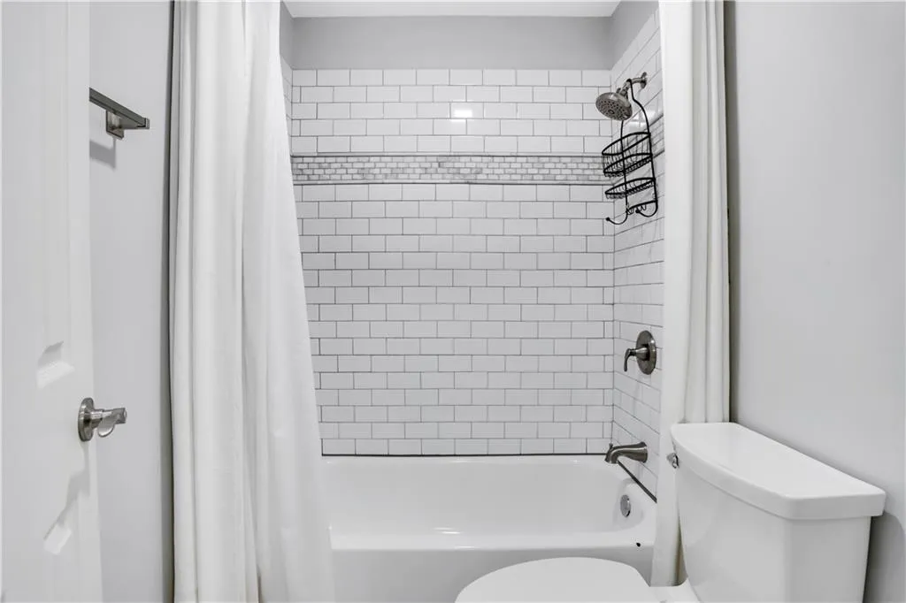 Bathroom with toilet and shower / bath combo with shower curtain Bathroom with toilet and shower / bath combo with shower curtain